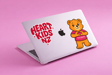 Load image into Gallery viewer, Laptop with 'Heart Kids NZ' and teddy bear decal on a pink background
