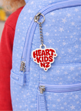 Load image into Gallery viewer, Blue backpack with a 'Heart Kids NZ' keychain